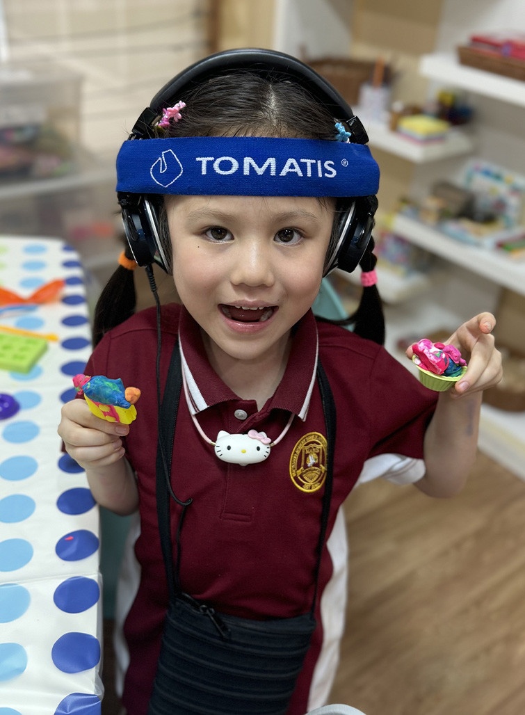 girl with headpones holding toys Tina